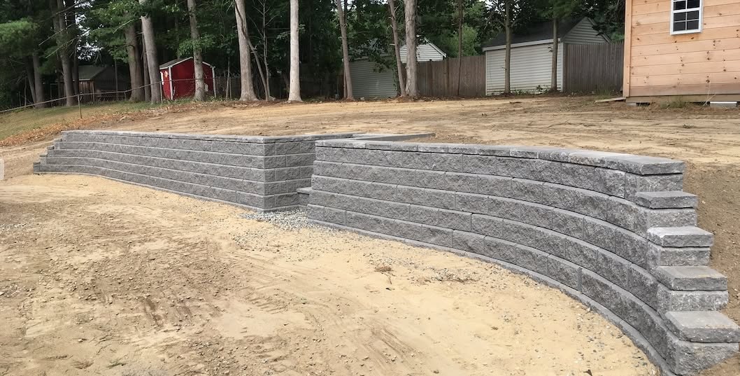 Curved Allan Block retaining wall in Granite Gray in a Raynham, MA backyard