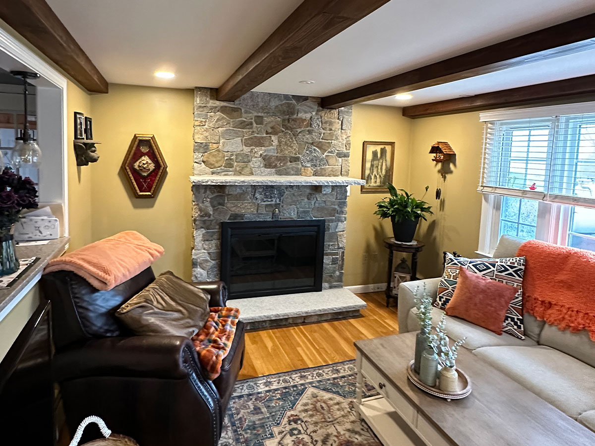 Completed Lexington Blend stone fireplace with granite mantel, hearth, and glass doors in Raynham, MA