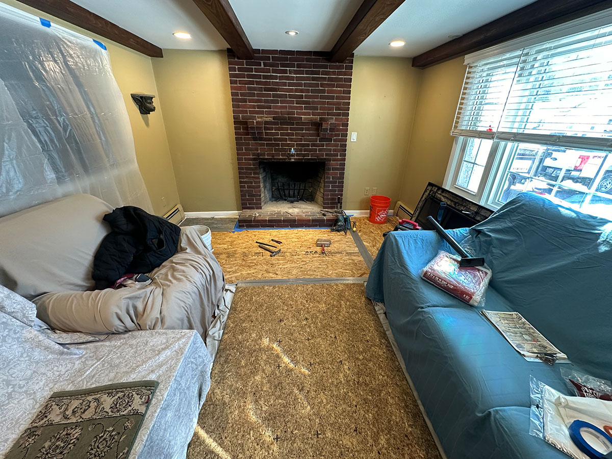 Original brick fireplace with floors and furniture protected before stone veneer refacing