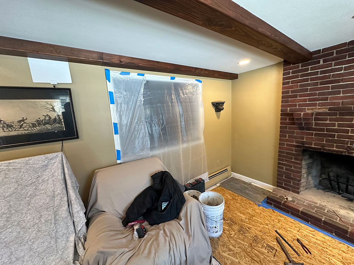 Window, furniture, and hardwood flooring protected during the interior fireplace project