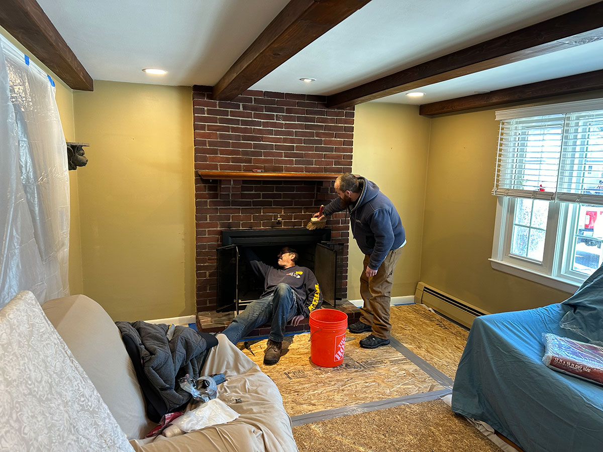 Cornerstone crew preparing the original brick fireplace and glass door assembly for refacing