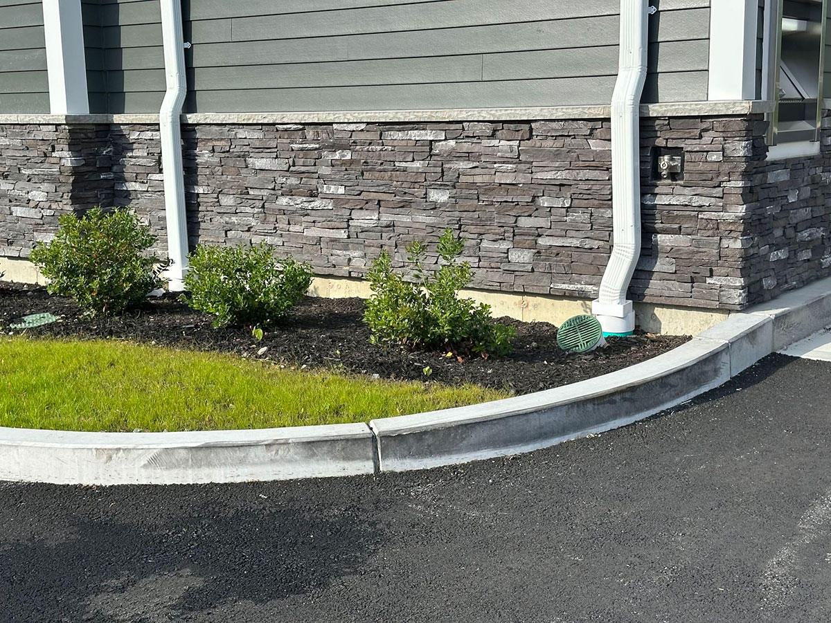 Close view of Dark Rundle manufactured stone veneer and a precast window sill