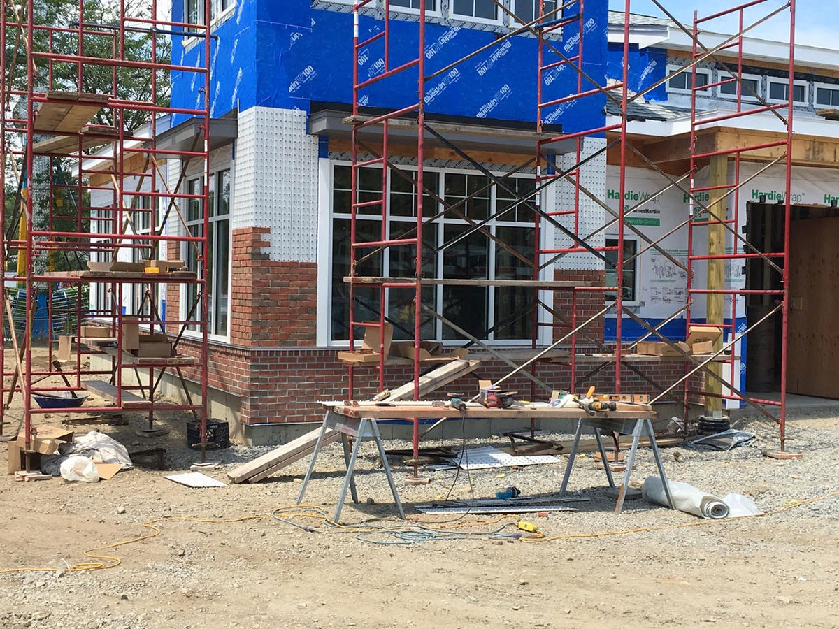 Commercial thin brick veneer installation in progress around bank windows