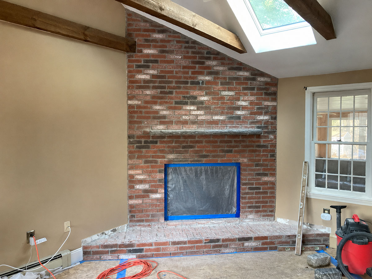 Existing brick fireplace prepared for stone veneer refacing inside an occupied home