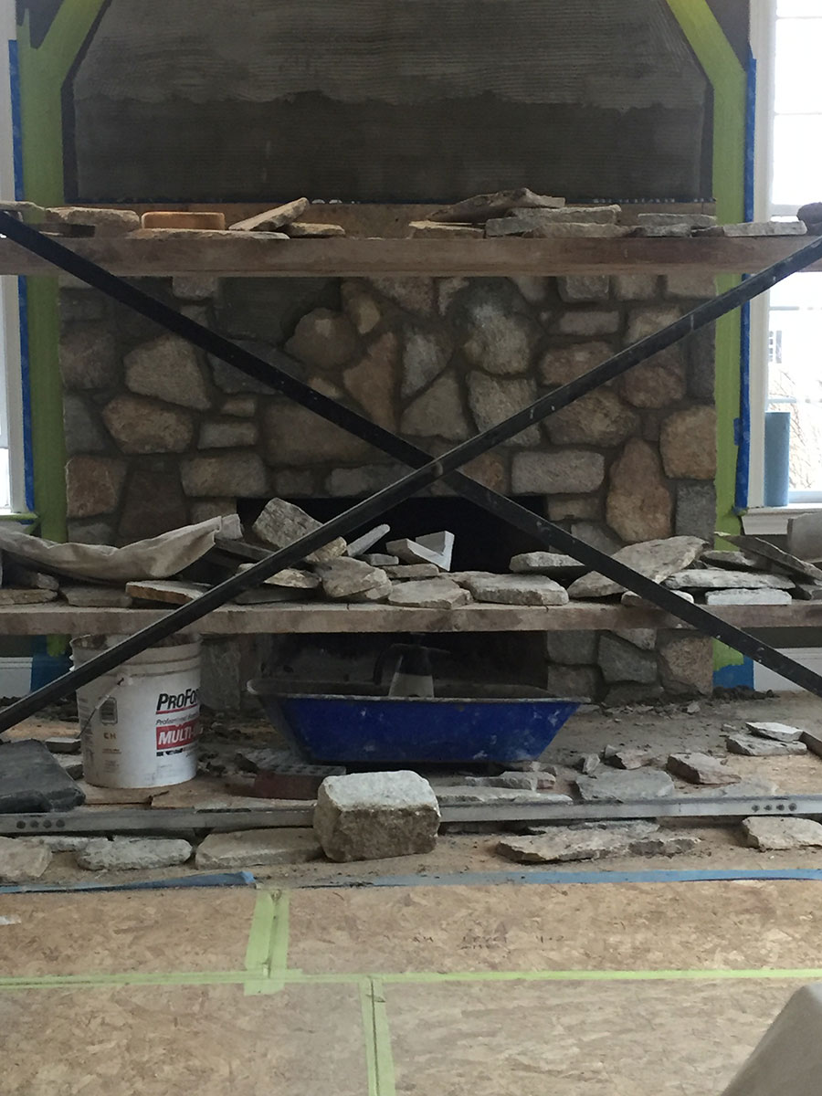 Boston Blend Mosaic natural stone veneer being installed around the fireplace opening