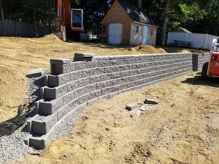 concrete block retaining wall with granite steps being built in raynham ma