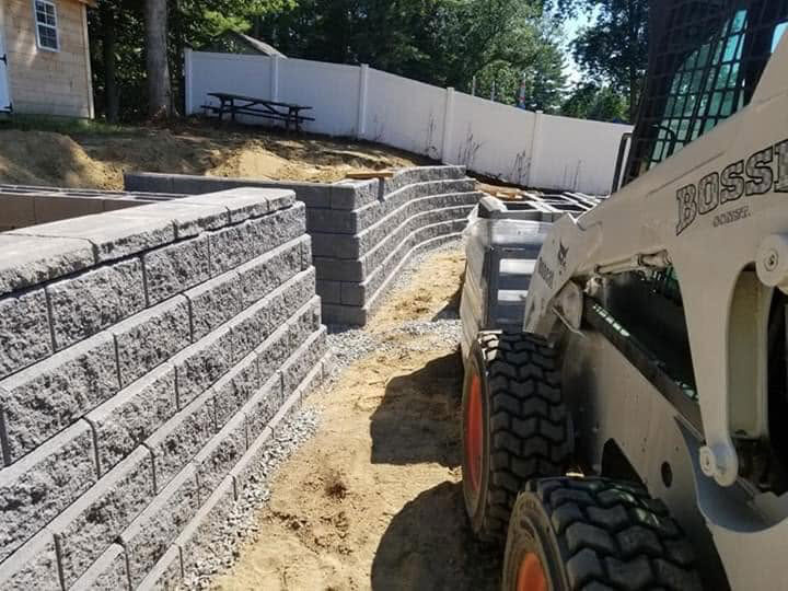 concrete block retaining wall being built in raynham ma