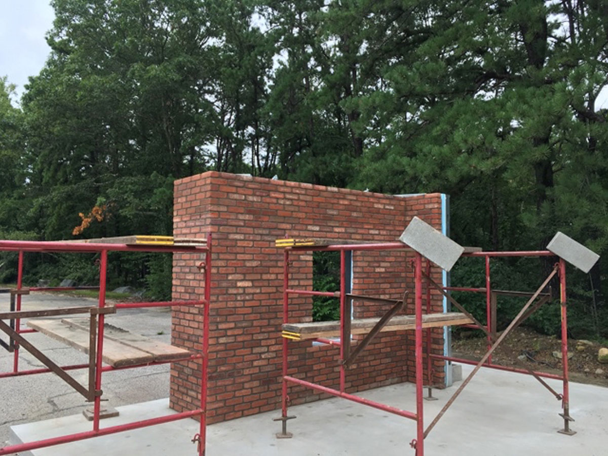 Dryvit NewBrick sample wall with two openings and scaffolding at the Rhode Island facility