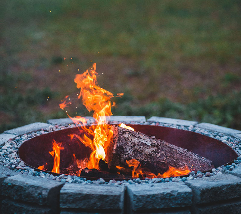 outdoor fire pit in use at night in backyard