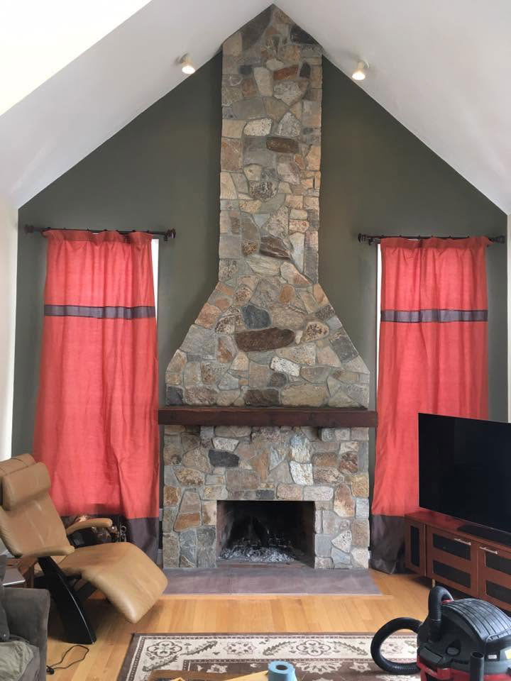 Floor-to-ceiling stone fireplace extending to the peak of a vaulted living room